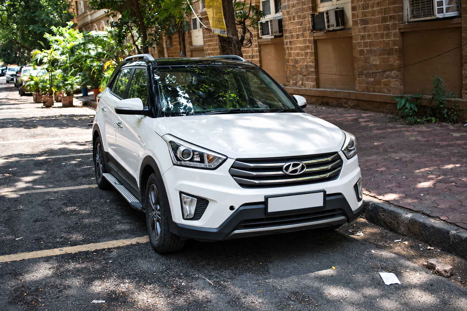 White Hyundai Creta parked on a leafy city street.