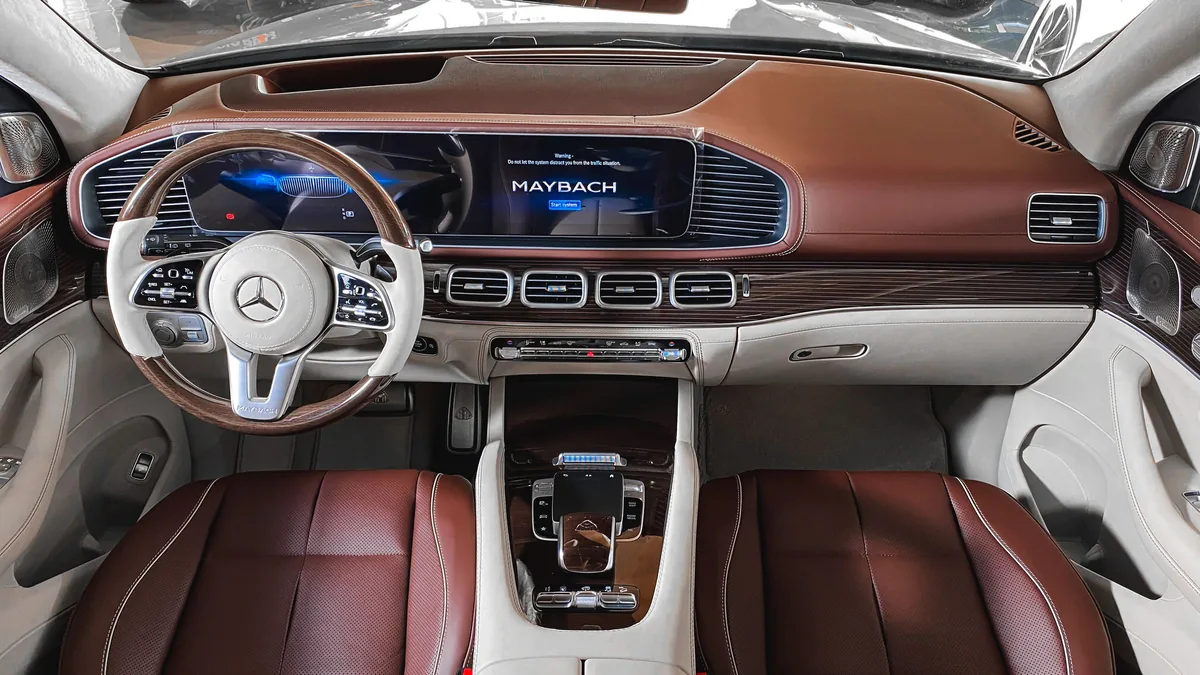 The front cabin of a luxury saloon, leather trim and instrument display lit.