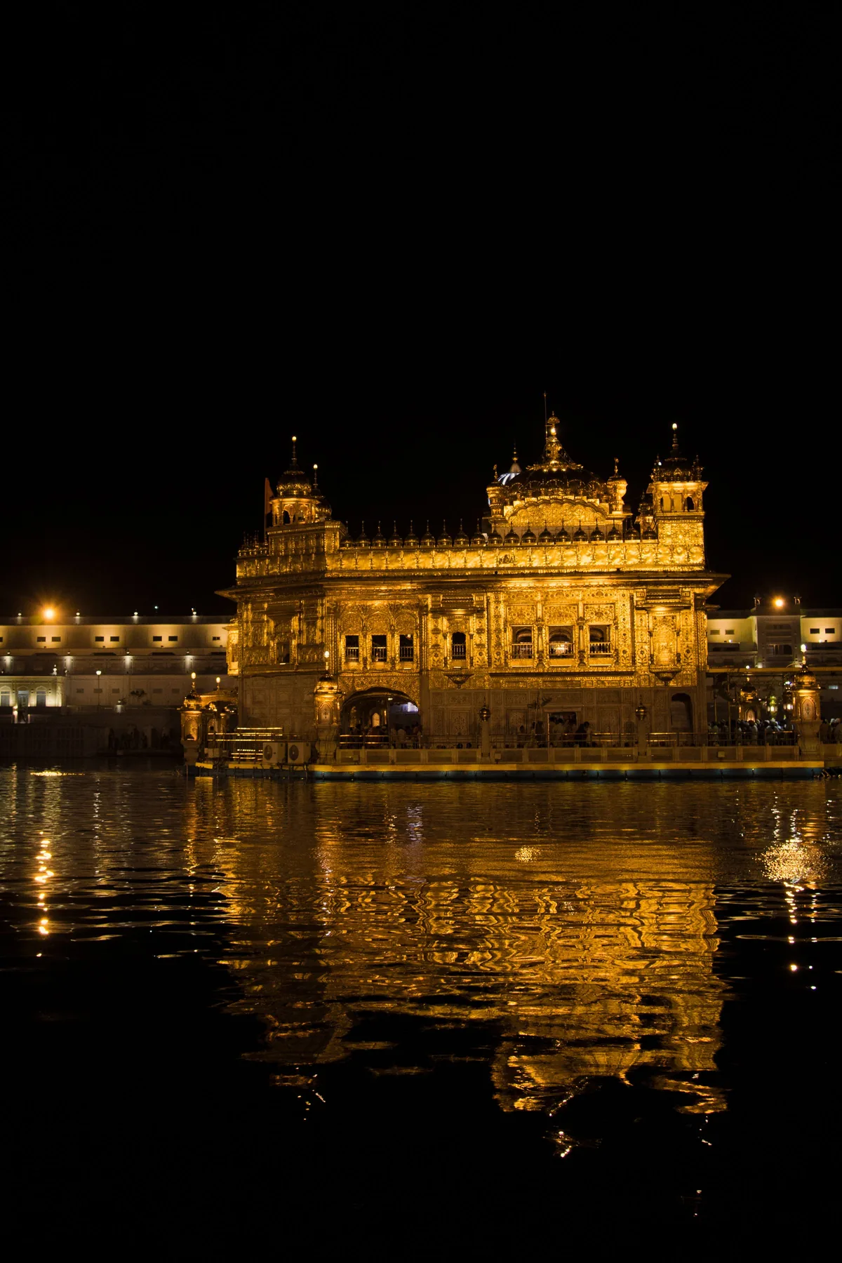 The Golden Temple at Amritsar lit at night and reflected in the surrounding water.