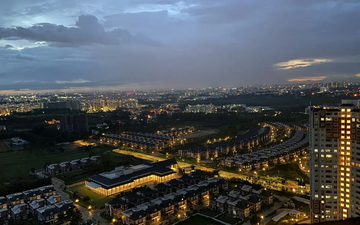 Bengaluru from the air at dusk, city lights coming on.
