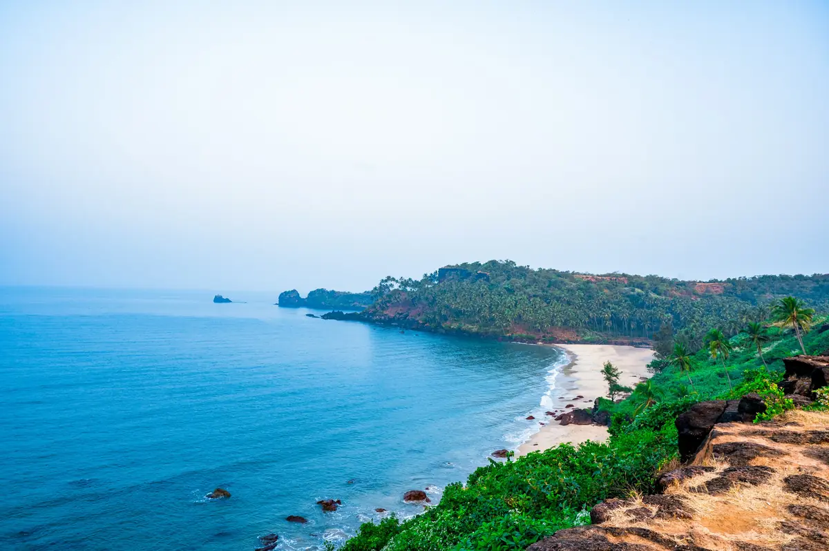A quiet Goan bay at midday, headland and open sea.