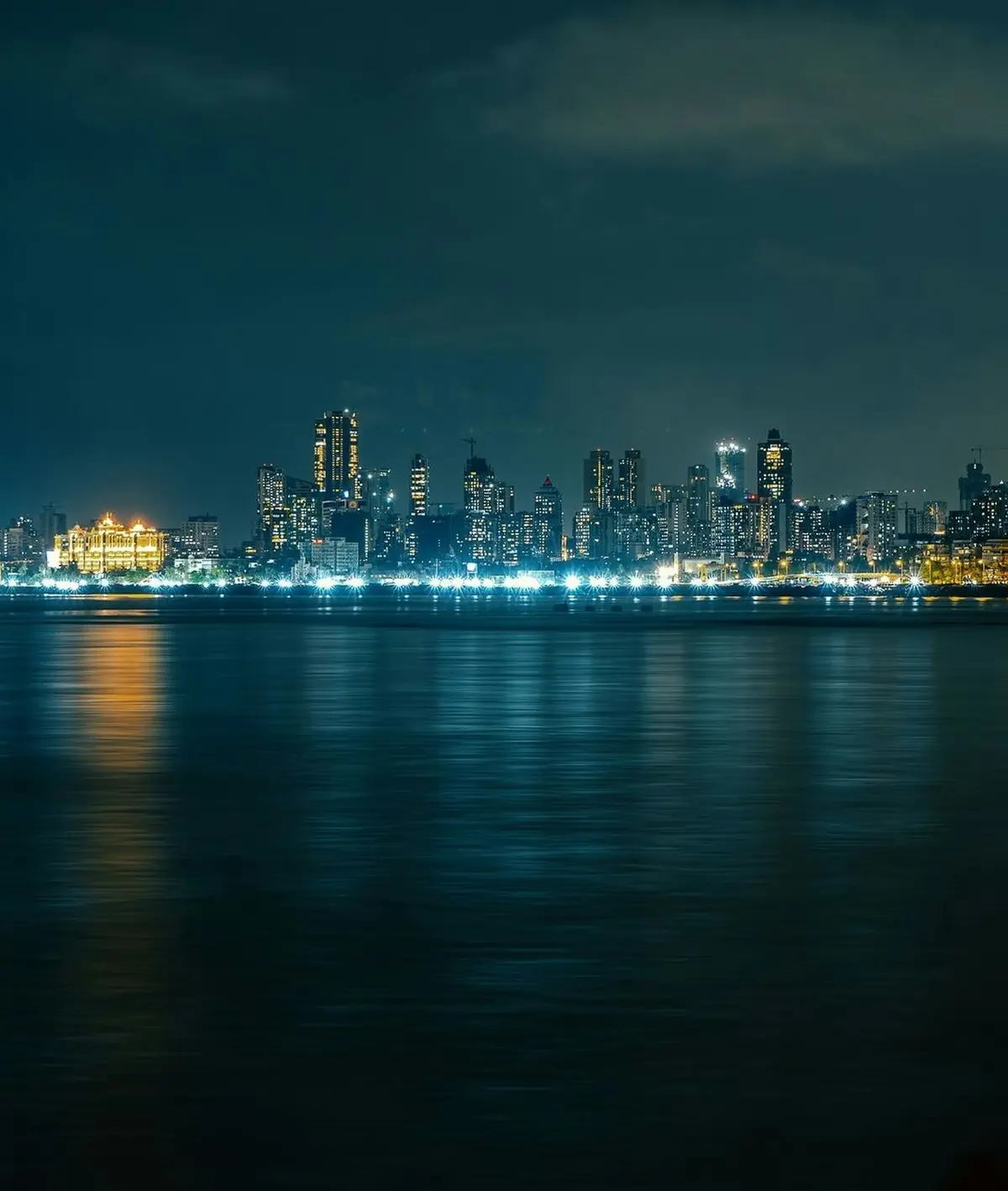 The Mumbai skyline at night, seen across the water.