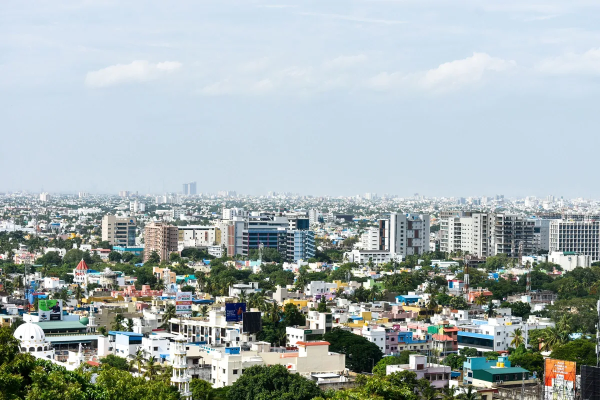 A modern Indian city spreading to the horizon under a pale sky.