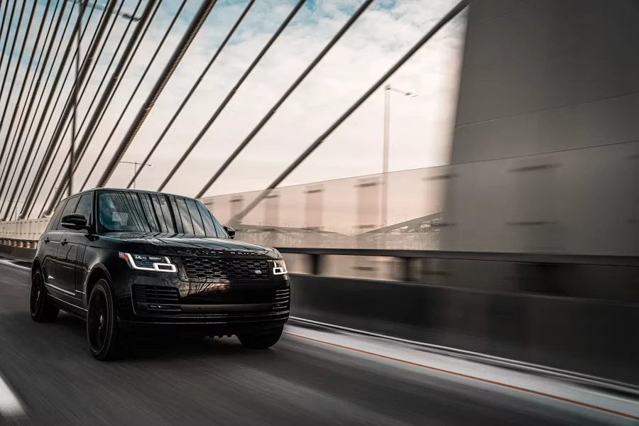Black Range Rover travelling across a bridge.