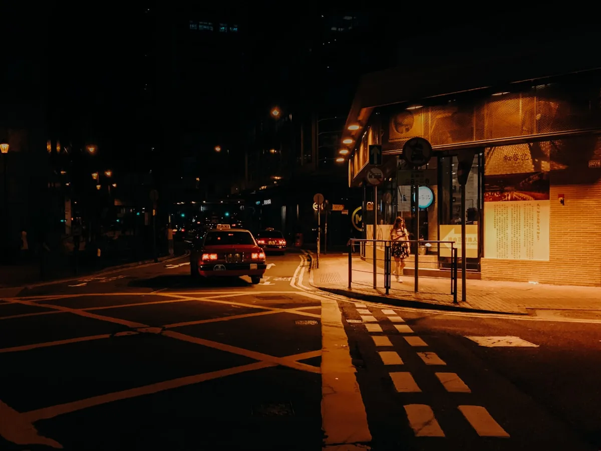 Vehicles packed along a lit road at night, viewed from an elevated position.